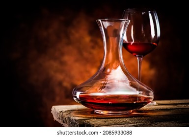 Wine in a decanter and glass on a wooden table
