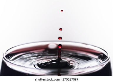 Wine drop splashing on glass.