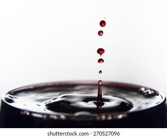 Wine drops splashing on glass.