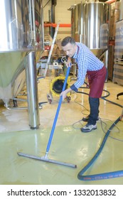 Wine Factory Worker Cleaning Floor