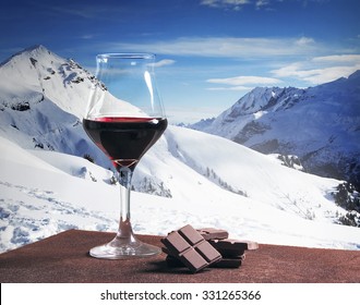 Wine Glass And Chocolate With Winter Mountainscape