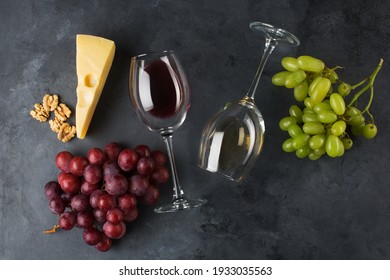 Wine glass, wine and grapes on black background