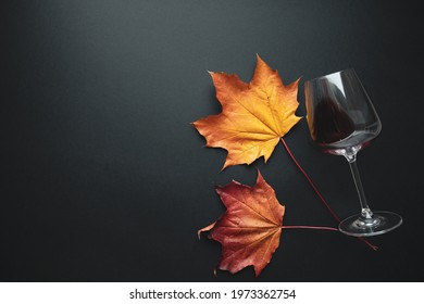 Wine glass with red wine and autumn grape leaves on black background. Creative wine degustation layout in rustic style, selective focus. Flat lay backdrop with copy space, top view. - Shutterstock ID 1973362754