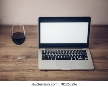 Wine glass with red wine and laptop computer - Powered by Shutterstock