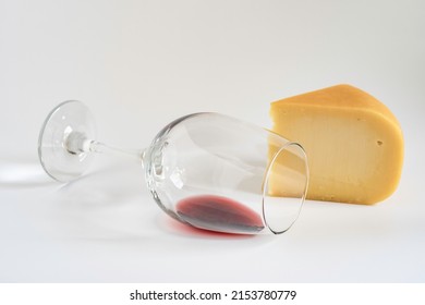 Wine Glass And Smoked Gouda Cheese On White Background.