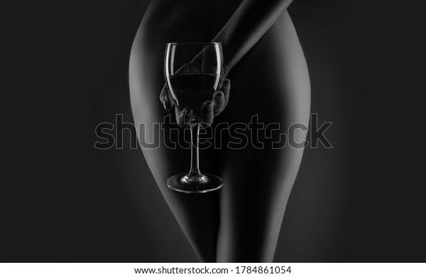 Wine.\
Glass white wine. Sensual woman holds in hand glass wine. Sensual\
womans body in dark background. Sensual\
concept