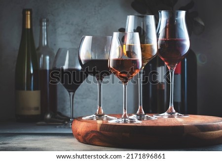 Wine glasses and bottles assortment. Red, white, rose wines on gray table background. Wine bar, shop, tasting concept