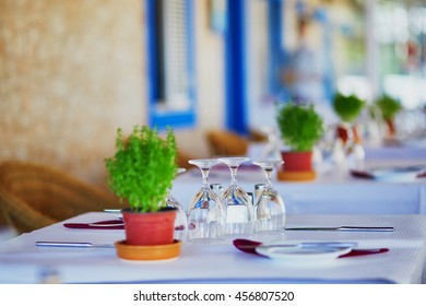 Wine Glasses And Green Plant On The Table Of Portuguese Restaurant In Algarve, Portugal
