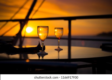 Wine Glasses On Balcony Overlooking At Sunset