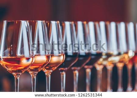 Wine glasses in a row. Buffet table celebration of wine tasting. Nightlife, celebration and entertainment concept. Horizontal, cold toned image