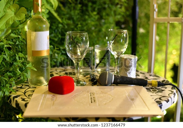 Wine, glasses,\
wedding rings and marriage contract prepared for a wedding ceremony\
at a Jewish traditional\
wedding