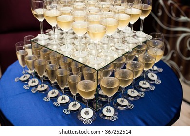 A lot of wine glasses with white tasty wine or champagne on the table at the ceremony. Close up Glasses with alcoholic drinks.