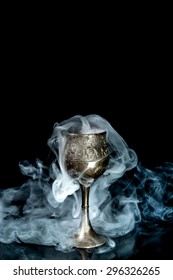 Wine goblet with smoke on black background