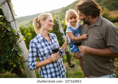 Wine Grower Family Tasting Wine In Vineyard