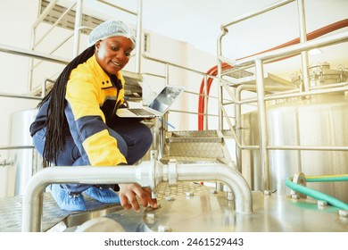 Wine industry : Portrait African American female looking at camera quality control worker working in a winery holding laptop computer recording data checking quality winery every production process. - Powered by Shutterstock