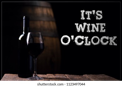 It's Wine O Clock. A Bottle Of Red Wine And A Glass With Barrel On Background