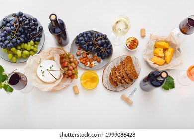 Wine Party Event Dinner Table With Set Cheese Grapes Honey Nuts. Festive Table Served With Red Wine And Mediterranean Food Appetizer Snack On White Background. Flat Lay Banner