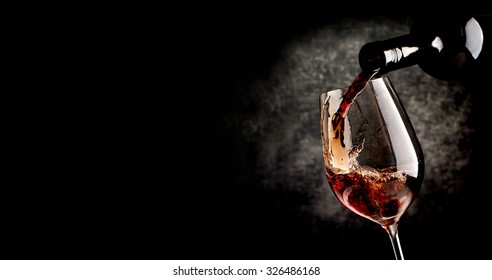 Wine Pouring In Wineglass On The Black Background