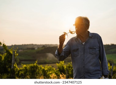 Wine producer man tasting the product after harvest and grape fermentation process - Vinification, organic quality product and small business concept - Main focus on hand - Powered by Shutterstock
