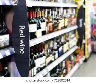 Wine Shelf Aisle In Supermarket With Red Wine Ad On Display In Foreground 