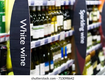 Wine Shelf Aisle In Supermarket With White Wine Ad On Display In Foreground 