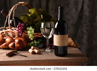 Wine Still Life On A Rustic Wood Table With Warm Afternoon Window Light. An Old Fashioned Cork Screw, A Basket Of Grapes And Leaves, Bread And Some Corks And An Empty Wineglass Round Out The Scene. 