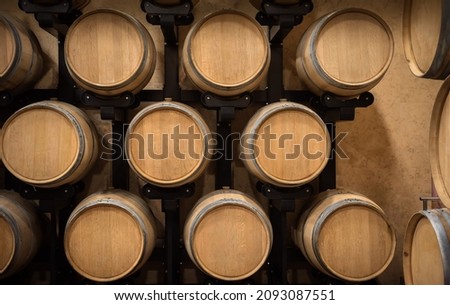 Wine storage, wooden wine barrels in a row in winery cellar