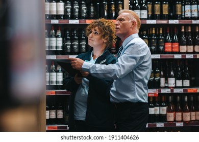 Wine Store Employees Doing Inventory. Sommeliers Doing Stock Take In Wine Store.