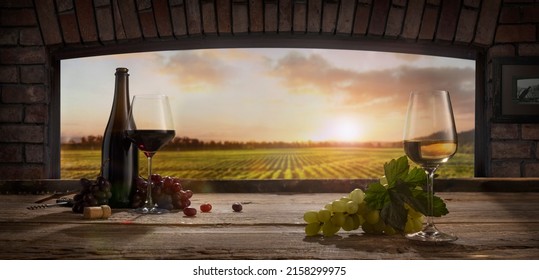 Wine tasting. Composition with wine glasses, bottles, grapes on wooden table in wine cellar. Panoramic window view of vineyards at sunset. Festivals, holidays, traditions and winemaking concept - Powered by Shutterstock