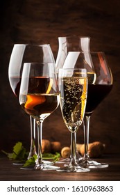 Wine Tasting Concept, Still And Sparkling Wines. Red, White Wine, Rose And Champagne In Wine Glasses On Vintage Wooden Table Background