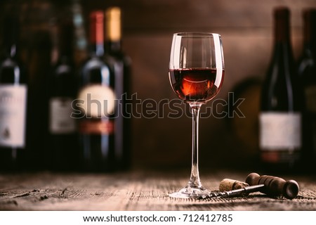 Wine tasting experience in the rustic cellar and wine bar: red wine glass and collection of excellent wines on the background Zdjęcia stock © 