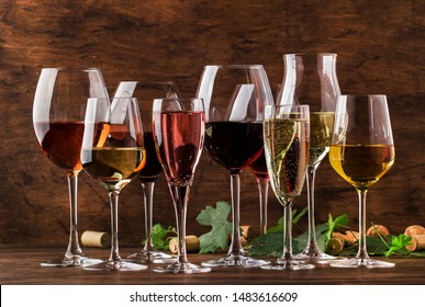 Wine tasting, still and sparkling wines. Red, white wine, rose and champagne шт assortment in wine glasses on vintage wooden table background - Powered by Shutterstock