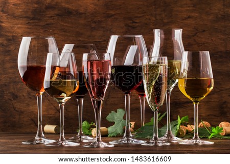 Wine tasting, still and sparkling wines. Red, white wine, rose and champagne шт assortment in wine glasses on vintage wooden table background