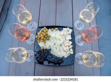 Wine Tasting At The Valley Of The Beautiful Women In Eger, Hungary. Six Glasses Of White And Rose Wines And A Cheese Plate With Grapes. The White Wines Are Of Leanyka And Olaszrizling Varieties.