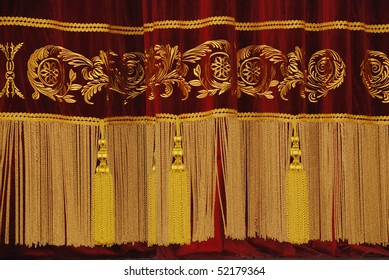 wine-coloured drape with gold fringe and tassels