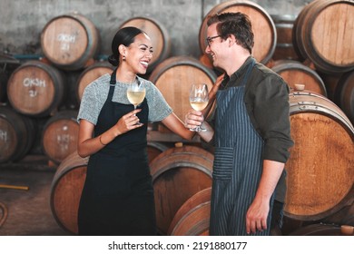 Winemaker business partners having fun talking at winery, white wine tasting and laugh. Young sommelier testing flavor and alcohol drink blend, bonding in cellar, celebrating good quality Chardonnay