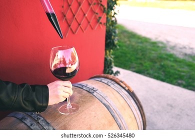 Winemaker Getting Sample Of Red Wine From Barrel
