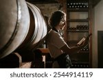 Winemaker Inspecting Bottle of White Wine in Cellar