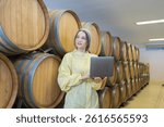Winemaker inspecting quality the process of fermentation during manufacturing in winery factory