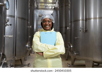 Winemaker inspecting quality the process of fermentation during manufacturing in winery factory and stainless tank. Female winemaker working in winery factory - Powered by Shutterstock