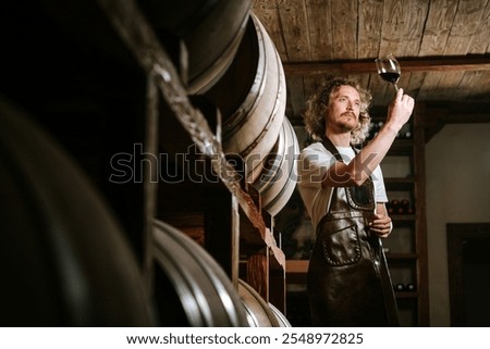 Winemaker Inspecting Red Wine in Cellar