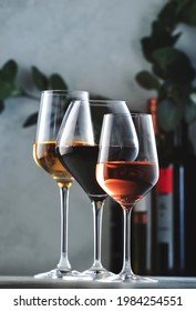 Wines Assortment. Red, White, Rose Wine In Wineglasses And Bottles On Gray Background. Wine Bar, Shop, Tasting Concept