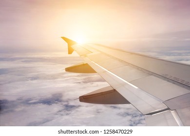 Wing Airplane Flying Above The Sky Soft Blurry Background. View From Airplane Window, At Sunset Outside Plane.