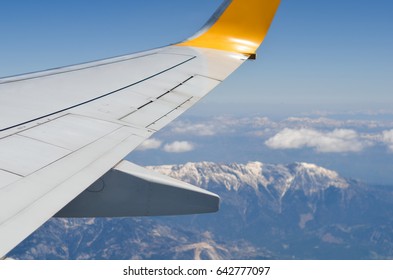 wing airplane in sky on background mountains