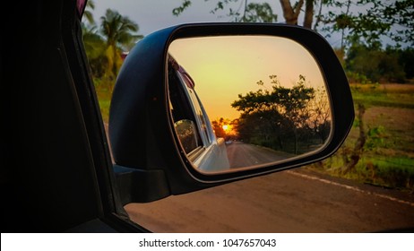 The Wing Mirror Of Stop Truck Car Show Evening Nature And Ricefield With Sunset On Old Asphalt Road. 