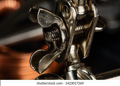 A Wing Nut & Thumb Screw Securing A Steel Ball Joint On A Piece Of Shop Equipment. Helping Hands Tools Used In Soldering, Macro Photography And Other Crafts Requiring The Ability To Hold Small Items.