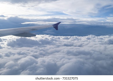 Wing of the plane flying over clouds.