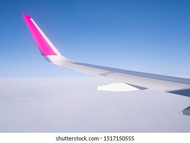 Wing Of Plane Over White Clouds. Airplane Flying On Blue Sky. Scenic View From Airplane Window. Commercial Airline Flight. Plane Wing. Flight Mechanics Concept. International Flight.