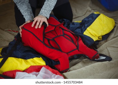 Wing Suit And A Parachute Satchel During Packaging, Close-up.