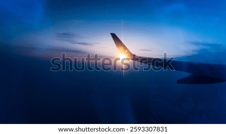 Wing at sunset through the window